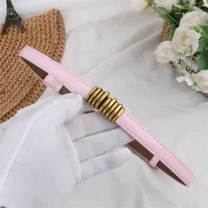 Detail shot of a stylish pink thin belt featuring a unique gold metallic ring buckle.