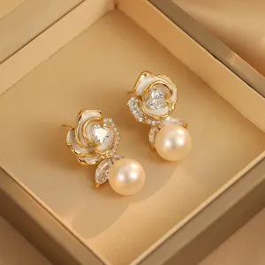 Nahaufnahme eleganter Rosenohrringe mit glänzendem Zirkonia-Herz und Champagner-Perle.