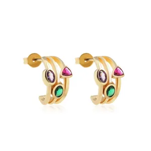 Nahaufnahme goldener Creolen mit bunten Zirkon-Edelsteinen in Pink, Lila und Grün