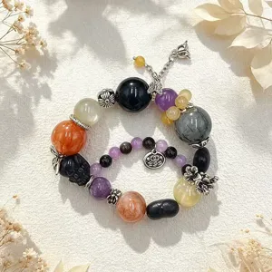 Detailaufnahme von bunten Kristallarmbändern mit Fuchs- und Blumenanhängern.