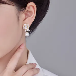 Detailaufnahme eleganter weißer Emaille-Rosenohrringe mit Zirkon und weißem Perlenanhänger