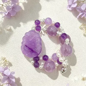 Detailansicht eines lila Amethyst-Armbands mit geschnitztem Fuchshänger und Perlen