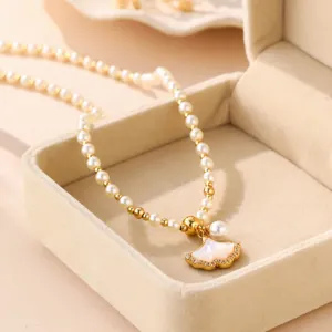 Elegante Perlenkette mit goldenem Ginkgoblatt-Anhänger in einer Schmuckschatulle