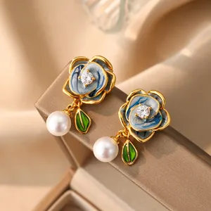 Detailaufnahme eleganter blau emaillierter Blumenohrringe mit Perlen und Zirkonia
