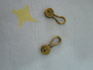 Close-up detail of vintage antique bronze zinc alloy belt hook and eye metal hardware parts.