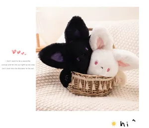 Close-up of cute black and white round bat plush dolls sitting in a woven basket