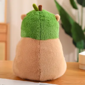 Schattige capibara knuffel met groene avocado-outfit op houten tafel