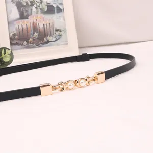 Detailed view of women's thin black leather dress belt with elegant gold pearl metal buckle.