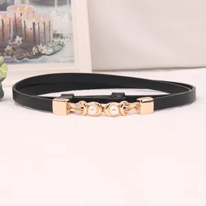 Close-up detail of a minimalist black thin waist belt featuring elegant gold metal pearl buckle.