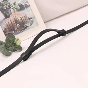 Black thin leather belt detail shot, slim dress strap, minimalist design for waist decoration.