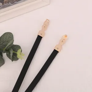 Black thin waist belt with gold decorative metal buckle, stylish accessory for women's dresses.
