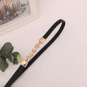Detailed view of women thin black belt with gold chain and pearl buckle for dresses.