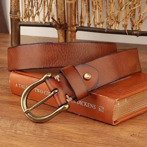 Close-up detail of retro brown genuine leather men's belt with vintage horseshoe buckle.