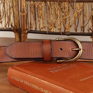 Detail shot of vintage genuine cowhide leather belt for men with classic metal horseshoe buckle.