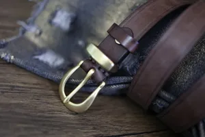 Λεπτομέρεια ρετρό καφέ δερμάτινης ζώνης με ορειχάλκινη πόρπη πέταλου σε τζιν.
