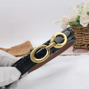 Black patent leather belt detail featuring a vintage gold double ring buckle for women.