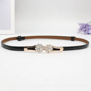 Nahaufnahme des schmalen schwarzen Damengürtels mit glänzender Strass Blumen Metallschließe.