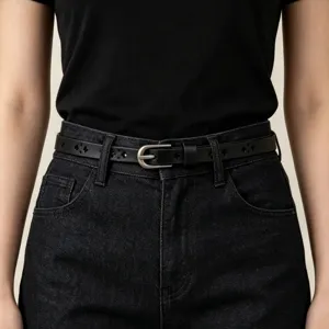 Black thin leather belt detail showing elegant cutout clover pattern and silver metal buckle.