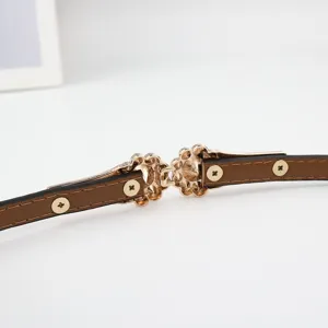 Eleganter schmaler Damen Ledergürtel in Braun mit filigranem goldenen Blumen-Metallverschluss.