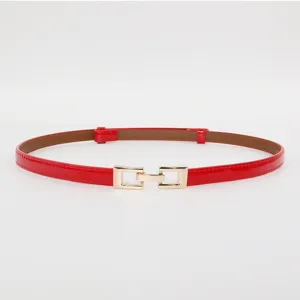 Close-up detail view of a chic red thin patent leather belt featuring elegant gold metal buckle.