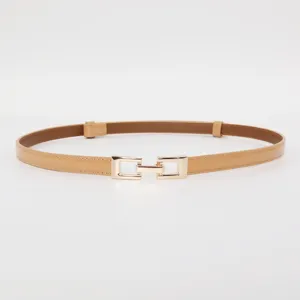 Close-up detail of a fashionable thin patent leather belt with a golden metal buckle.