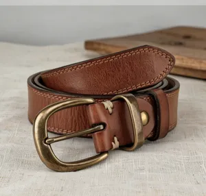 Close-up detail of women vintage genuine leather belt with antique brass buckle and stitching.