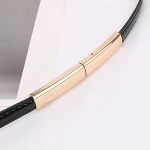 Ceinture fine en cuir noir avec boucle métallique dorée design minimaliste élégant