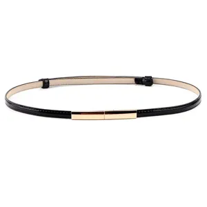 Ceinture fine en cuir noir avec un fermoir métallique doré gros plan mode femme.