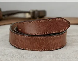 Close-up detail of the brown vegetable-tanned leather belt showing neat contrast stitching.