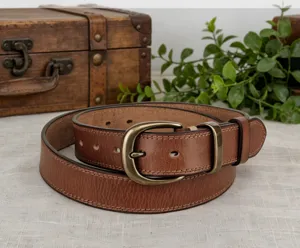 Detail view of a vintage brown leather belt featuring fine stitching and a classic brass buckle.