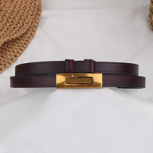 Dettaglio in primo piano della cintura da donna in pelle marrone scuro con fibbia dorata.