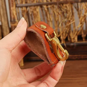 Close-up of brown leather belt keychain loop with brass metal snap hook accessory detail.