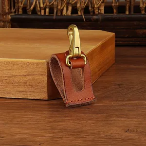 Detailed view of creative leather belt key clip with brass hook, durable brown leather accessory.