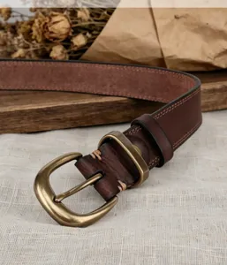 Close up of vintage genuine leather women belt with antique brass buckle and stitching details.