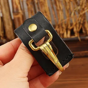 Close-up detail of black leather belt key holder with durable gold metal clasp and snap button.
