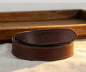 Close-up detail of vintage dark brown leather belt with neat contrast stitching and fine texture.