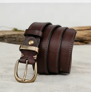 Detailed view of genuine leather vintage women belt with brass buckle and stitching.