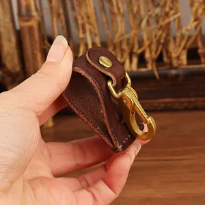 Leather belt key clip detail showing durable brass hook and snap fastener construction.