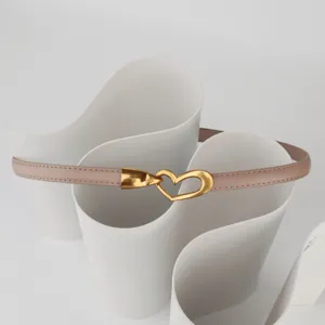 Detailed view of the elegant slim leather belt with a chic gold heart buckle, perfect for dresses.