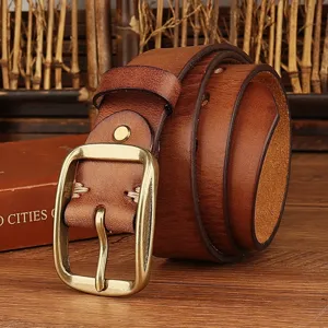 Detailed shot of vintage brown leather belt with retro metal pin buckle for casual look.