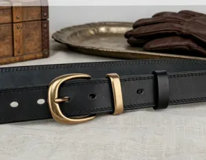 Close-up detail of the vintage black leather belt with contrast stitching and solid brass buckle.