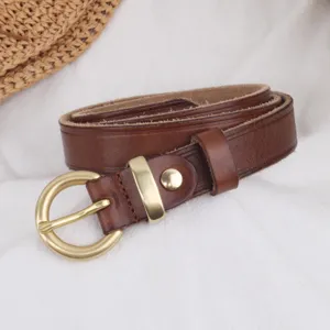 Brown genuine leather belt for women with elegant gold metal round buckle detail close-up view.