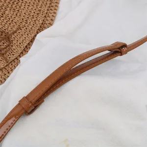 Detailed shot of a brown patent leather belt strap showcasing fine stitching and buckle design.