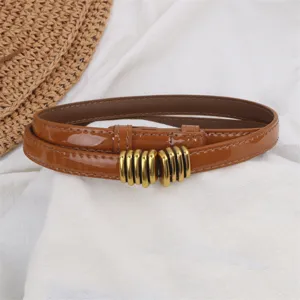Brown patent leather thin waist belt detail view, elegant metal buckle accessory for women.