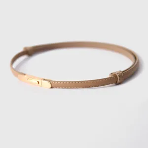 Detailansicht des minimalistischen Damen-Ledergürtels in Beige mit goldenem Metallverschluss.