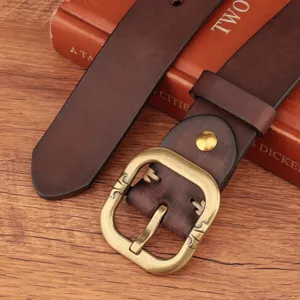 Close-up detail of retro genuine leather belt with vintage brass buckle and stitching.