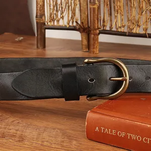 Close-up view of men's vintage genuine leather belt with classic metallic horseshoe buckle.