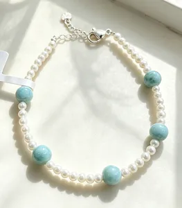 Detailed view of handmade bracelet with freshwater pearls and light blue Larimar stones