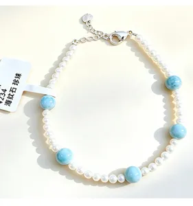 Close-up of handmade bracelet featuring blue larimar beads and freshwater pearls