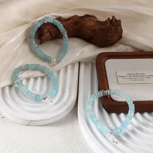 Macro detail of natural light blue aquamarine bead bracelet with white crystal charm